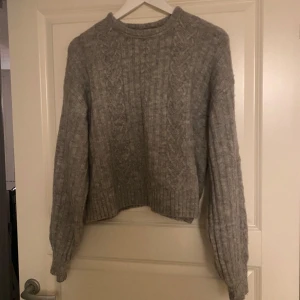 Grå stickad tröja från H&M - Mysig grå stickad tröja från H&M med kabelstickat mönster. Använt några gånger men fint skick 