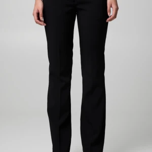 Svarta kostymbyxor - Snygga svarta kostymbyxor med en klassisk och stilren design. Byxorna har en bootcut passform och är perfekta för en elegant look. De är lågmidjade och tillverkade i ett bekvämt material som ger en smickrande siluett. Säljer då de inte kommer till användning längre, köpta för 500.