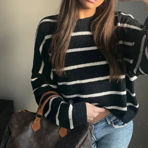 Svart och vit randig tröja - Säljer en svart och vit randig tröja med långa ärmar. Tröjan har en avslappnad passform och är perfekt för en casual look. Den är mjuk och bekväm, idealisk för kyligare dagar.