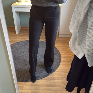 Svarta kostymbyxor - Snygga svarta kostymbyxor från ginatricot med medelhög midja och rak passform. Perfekta för en stilren look. Byxorna har en klassisk design med dragkedja framtill. Jag är 179cm lång 