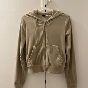 Beige hoodie från Gina Tricot - Säljer en snygg beige hoodie från Gina Tricot i storlek XS. Den har en dragkedja framtill och praktiska fickor. Perfekt för en avslappnad stil.