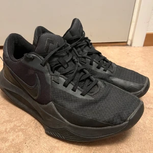 Svarta Nike sneakers - Snygga svarta Nike sneakers med snörning och en diskret Nike-logga på sidan. Skorna har en sportig design med en bekväm sula, perfekt för vardagsbruk.