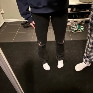 Svarta jeans med slitningar - Snygga svarta jeans med slitningar vid knäna. Dom är Low waist och bootcut säljer för jag har 2 par likadana 