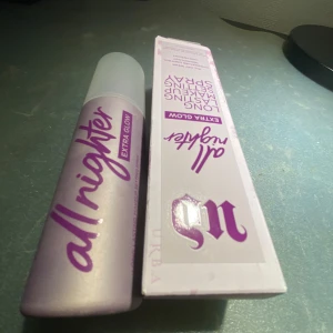 All Nighter Extra Glow Setting Spray - Urban Decay All Nighter Extra Glow Setting Spray ger en långvarig och strålande finish. Perfekt för att hålla sminket på plats hela dagen med en extra glöd. Kommer i en stilren flaska med lila text och en vit kork.