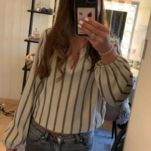 Randig blus - Säljer en stilren randig blus från Lindex i vitt och svart. Blusen har långa ärmar med elastiska muddar och en v-ringad hals. Storlek M, men skulle säga att det mer är S. Knappt använd💓Köpt för 300.
