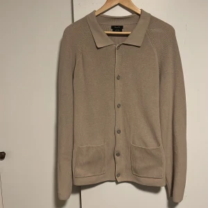 Beige kofta från Massimo Dutti - Säljer nu denna cardigan/koftan från Massimo Dutti i stl L. Den är enbart använd några enstaka gånger och är i mycket fint skick. Jag är 190 cm lång. Vid fråga är det bara att skriva. 