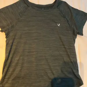 Säljer en grå t-shirt från SOC med korta ärmar och ett diskret mönster. Perfekt för träning med sitt bekväma material och stilrena design. Liten logga på bröstet ger en sportig touch. Använd men fortfarande i bra skick.🙌