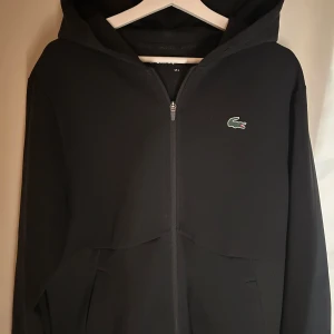 Lacoste Zip Hoodie - Clean lacoste zip i mycket bra skick! Använd 1 gång och har inga defekter💯Byte är möjligt!!