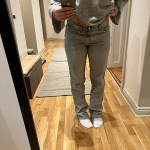 Grå jeansbyxor - Snygga grå jeansbyxor med en klassisk straight passform. De har en lågmidjad design och är perfekta för en avslappnad stil. Byxorna har traditionella fem fickor och en dragkedja med knappstängning.