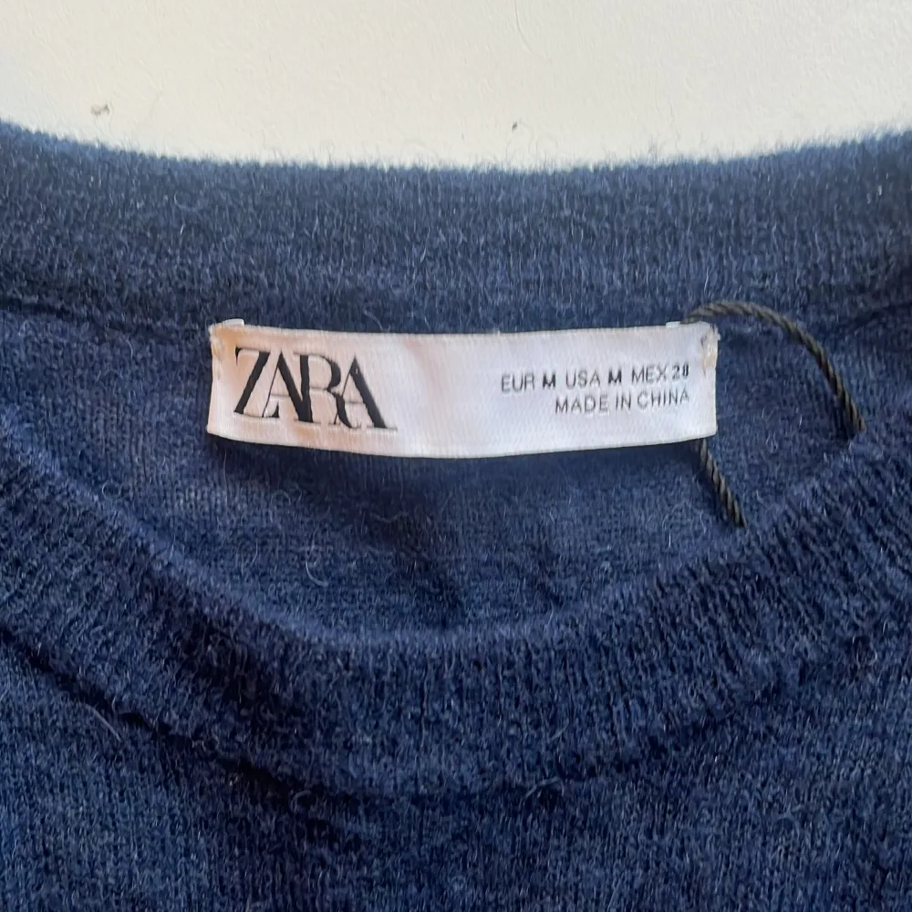 Säljer en stilren mörkblå tröja från Zara. Tröjan har en enkel design med långa ärmar och är tillverkad i ett mjukt material. Perfekt för en avslappnad look.. Neuletakit & Villapaidat.