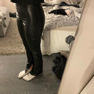 Svarta skinnbyxor med slits - Snygga svarta skinnbyxor med slits vid anklarna. De har en tight passform 