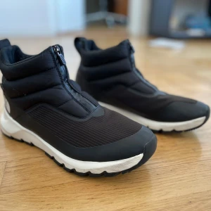 Svarta boots från The North Face (Thermoball Progressive II) - Snygga svarta boots från The North Face med Thermoball Eco-isolering. De har en dragkedja framtill och en robust sula för bra grepp. Perfekta för kyligare väder. Mer detaljer här: https://www.thenorthface.se/sv-se/p/skor-747784/thermoball-progressive-ii-waterproof-zip-up-winter-boots-w-NF0A5LWF