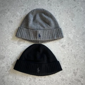 PAKETPRIS🍾!                 Ralph Lauren mössor  - Två stilrena mössor från Ralph Lauren i grått och svart. Båda mössorna är ribbade och har den ikoniska broderade logotypen framtill. Perfekta för kyliga dagar. Kom med bud🙌🏼🍾🤩