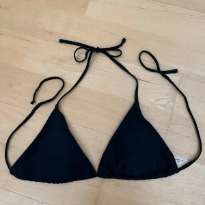 Svart bikiniöverdel - Snygg svart trekantsbikini med knytband i nacken och ryggen.            I nyskick och aldrig använd.  