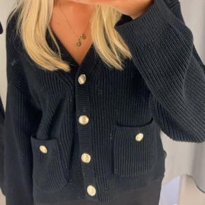 Svart stickad kofta med guldknappar - Snygg svart stickad kofta med guldknappar och två praktiska fickor framtill. Jättefin och i jättebra skick!💓