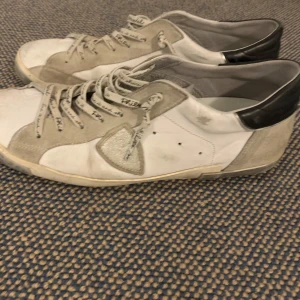  Philippe Model - Snygga vita sneakers från Philippe Model med gråa och svarta detaljer. Skorna har snörning och en stilren design med en kombination av skinn och mocka. Perfekta för en avslappnad stil.