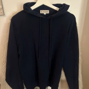 Mörkblå hoodie från Studios - Säljer en stilren mörkblå hoodie från Studios i storlek M. Tröjan är cashmere och slutsåld överallt! Nypris 1000