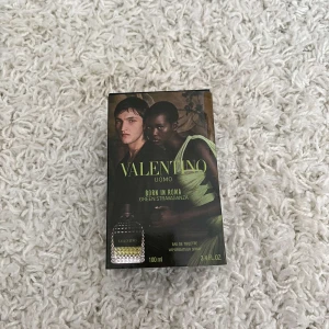 Valentino Uomo Born in Roma Green - Säljer en flaska Valentino Uomo Born in Roma Green Stravaganza. Flaskan är svart med ett elegant nitat mönster och har en grön etikett med märkesnamnet. Den rymmer 100 ml och är en eau de toilette. Perfekt för den som vill ha en unik och stilren doft.