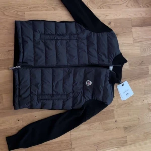 Svart quiltad jacka från Moncler - Snygg svart quiltad jacka från Moncler med långa ärmar och dragkedja. Perfekt för kyligare dagar med stilren design och Moncler-logga på bröstet. jag har använt denna cardigan 3 gånger och den är i väldigt bra skick ja köpte den från nk då jag har kvitto.