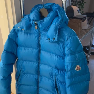 Moncler Maya Blå - Säljer denna moncler maya i en väldigt sällsynt colorway som inte säljs längre. Storlek 1/S. Jackan är givetvis äkta och är köpt från SaintGarms. Skicket är väldigt bra utan defekter, skulle säga 8-9/10, bara general wear. Cartoonen satt lite löst förut men det är fixat av en skräddare. Lägger mest ut för att kolla intresset men säljer vid rätt pris. Hör av dig om du har frågor! 