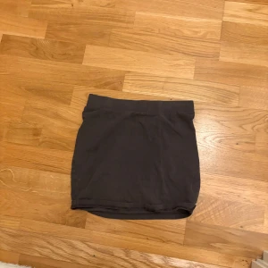 Grå kjol från H&M - Snygg grå kjol från Divided i en enkel och stilren design. Perfekt för att matcha med olika toppar. Kjolen är kort och har en elastisk midja för bekväm passform.