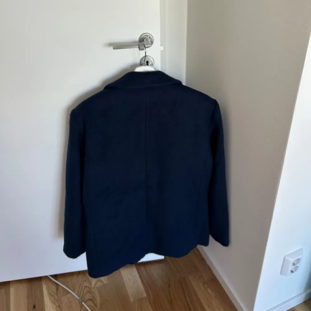 Slutsåld mörkblå kavaj från Gina Tricot. Strl M. Använd 1-2 ggr, som ny!💖 Beskrivning från hemsidan: Oversized jacket in men's style with wide sleeves. The jacket is blue and has a brushed quality in wool mix. It has one-button fastening at the front, dropped shoulders, collar with notch lapel, welt pockets with flaps in the sides and a chest pocket.. Takit.