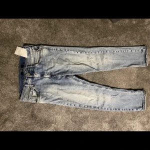 Blå jeans från Replay - Snygga blå jeans från Replay med en klassisk femficksdesign. De har en lätt tvättad look och raka ben. Perfekta för en avslappnad stil.Dom har hål i högra fickan
