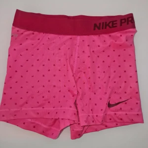 Rosa träningsshorts från Nike - Snygga rosa träningsshorts från Nike med ett diskret rutmönster. Använd 2 gånger. Garderobsrensning så kika gärna på övriga auktioner. 