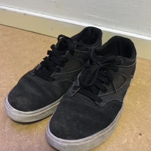 Svarta sneakers från DC Shoes - Svarta sneakers från DC Shoes med snörning och vit sula. Perfekta för en avslappnad stil. Märkeslogga synlig på plösen.