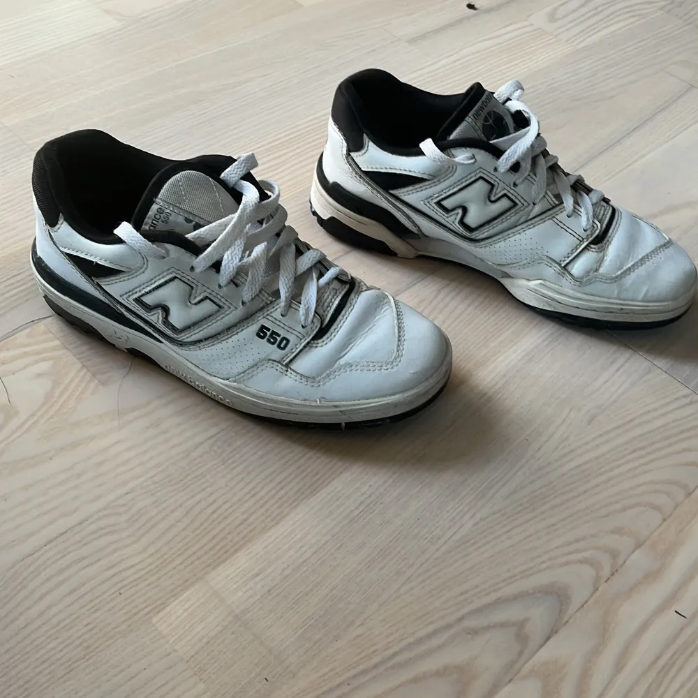 Säljer ett par vita New Balance 550 sneakers. De har en klassisk design med snörning och en svart detalj på hälen.  skick 7/10. Perfekta för vardagsbruk! Hör  av dig vid snabb affär!!!! . Skor.