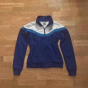 Blå Zipup Nike tröja  - Blå zip up Nike tröja. Köpt på second hand för typ ett år sen. Säljer dyrt för de bra skick o Nike. Andväns inte för inte är min stil längre. Bra skick, inga hål eller skada. Kp om frågor eller fler bilder.