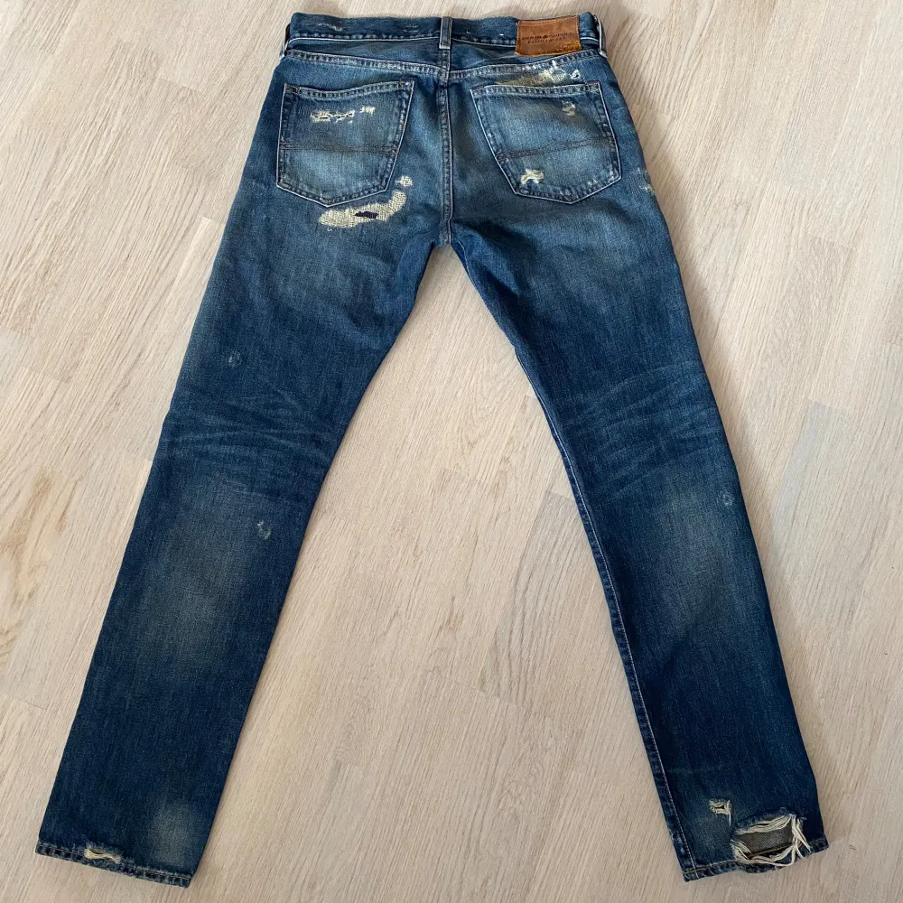 Säljer ett par Ralph Lauren jeans med riktigt snygg tvätt och slitningar. Jeansen är mycket sparsamt använda, alla slitningar är orginal. Jeansen passar som bäst 180 - 185 och är en slim modell. Vid minsta fråga eller fundering är det bara att skriva. Jeans & Byxor.