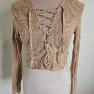 Beige ribbad tröja från H&M Divided - Croppad topp med snörning från hm divided.