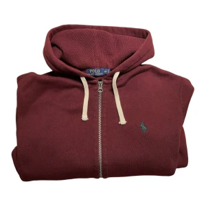 Ralph Lauren Huvtröja - Ralph Lauren huvtröja i en snygg vinröd färg. Tröjan är i mycket bra skick men med små slitningar vid muddarna. Känn dig fri att fråga om du skulle undra något mer!