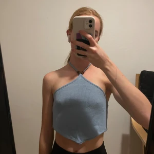 Bandeau topp - Triangelbandeau topp i stickat material med halterneck. Knytning i ryggen och kring halsen. Bruna pärlor på alla snören. Endast använd ett fåtal gånger 