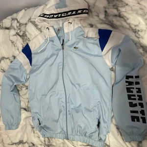 Lacoste regn hoodie  - En helt ny oanvänd zipup Lacoste regn hoodie. Säljs för behovet av pengar. 