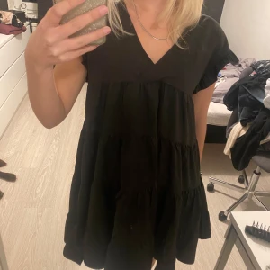Svart sommarklänning  - Svart ”buffig” sommar klänning Välanvänd  Har en fläck längst fram men borde nog kunna tas bort 100% polyester 