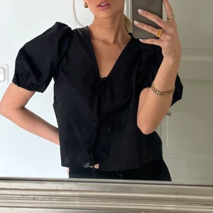 Svart blus med puffärm  - Svart blus med puffärm och knyt från Gina Tricot. Sparsamt använd 🩷