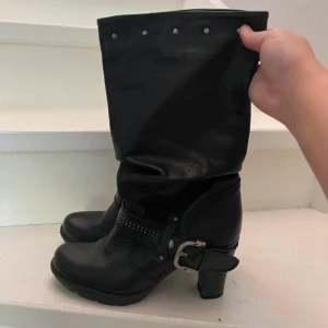 Svarta boots med nitar och spänne - Säljer ett par svarta boots i skinn med coola detaljer. De har ett snyggt spänne och nitar. Ny skick 