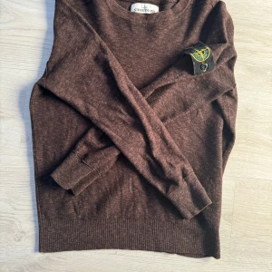 Brun tröja från Stone Island - Säljer en snygg brun tröja från Stone Island. Den är i storlek S och har långa ärmar. Perfekt för höst och vinter med sin mysiga och stilrena design. Tröjan är i bra skick och passar både till vardags och lite finare tillfällen.