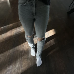 Jeans från Zara - Grå jeans med hål i knäna från zara i bra skick. Uppsydda ca 3cm. Storlek 32