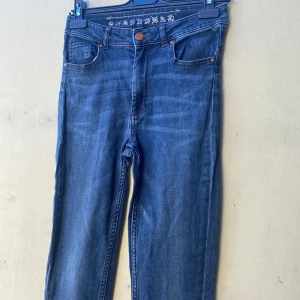 Mörkblå jeans - Säljer ett par mörkblå jeans i bra skick. De har en klassisk femficksdesign med knapp och dragkedja framtill. Perfekta för vardagsbruk och kan matchas med nästan vad som helst. Storleken är 28 tum i midjan.