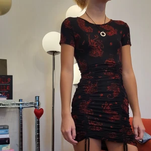 Svart klänning med röda detaljer - Snygg klänning med snygga detaljer undertill, och röda leoparder.