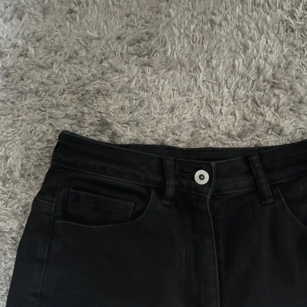 Svarta stretchiga bootcut jeans med hög midja, knappt använda inga tecken på användning passar storlek S - W28L32, hög midja Midja 34 cm Innerlår 81 cm Hela byxans längd ca 105 cm. Jeans & Byxor.