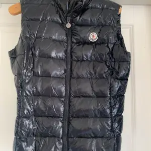 Snygg dunväst från Moncler, svart blank. Skicket är som ny! Grymt snygg dunväst, sitter för tajt på mig därför säljer jag den. 