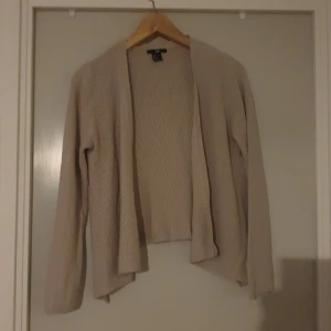 Beige stickad kofta - Säljer en supermysig beige stickad kofta. Perfekt för kyliga dagar med sin långa ärm och öppna design. Den har en fin textur som ger lite extra stil. Passar perfekt till både vardag och lite finare tillfällen. 🧥✨