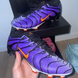 nike tn fotbollskor - jag säljer mina gamla fotbollskor storlek 42 den är lite sönder under fast går att använda utan problem, man kan lima om man vill. 