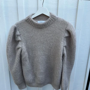 Beige stickad tröja från Zara - Säljer en superfin beige stickad tröja från Zara. Den har långa ärmar och en mysig, ribbad struktur. Perfekt för höst och vinter när man vill hålla sig varm och stilren. Tröjan är i storlek 13-14 år, vilket motsvarar dam s. Knappt använd.