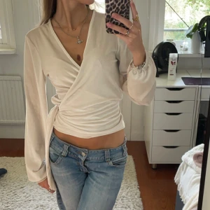 Omlottopp - Jättefin omlottopp / omlottblus. ❤️ Champagnefärg med lätt skimmer, perfekt till vardags eller finare tillfällen! 🫶🏻 Jag har vanligtvis XS och denna blus är M, så passar flera storlekar eftersom att man kan ”spänna åt” mer eller mindre! 🥰