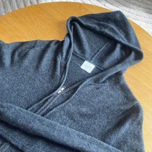 John Henric hoodie - En extremt fet mörk grå John Henric hoodie i 100% cashmere, tröjan är använd Max 5 gånger. Pris kan diskuteras vid snabb affär!